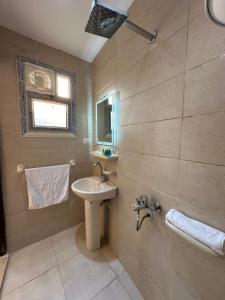 a bathroom with a sink and a mirror and a shower at sun 3 pyramids view hotel in Cairo +94 photos