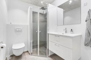 a white bathroom with a shower and a toilet at 781-Hvide-Sande-Norregade-2-nr-9 in Hvide Sande +25 photos