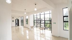 a large white hallway with chairs and windows at Hotel Harvest Retalhuleu in Santa Cruz Muluá