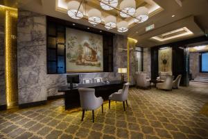 a hotel lobby with a desk and chairs at Zhaolin Grand Hotel in Beijing