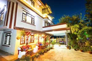a large white building with a patio in front of it at D Eco Resort in Dhulikhel