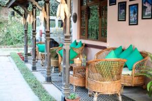a group of wicker chairs and tables on a patio at D Eco Resort in Dhulikhel