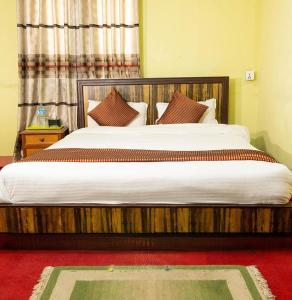 a bedroom with a large bed with white sheets and pillows at D Eco Resort in Dhulikhel