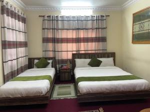 a bedroom with two beds and a window at D Eco Resort in Dhulikhel