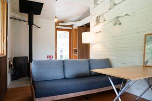 a living room with a blue couch and a table at White Bird in Hokuto