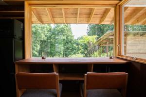 a large window in a kitchen with a table and chairs at White Bird in Hokuto