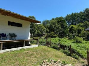 a house with a deck with a chair on it at White Bird in Hokuto