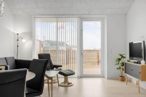 a living room with a table and chairs and a television at 771-Hvide-Sande-Norregade-2-nr-28 in Hvide Sande
