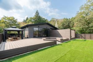 a large backyard with a wooden deck and a gazebo at なか富士 -Nakafuji- in Fujinomiya
