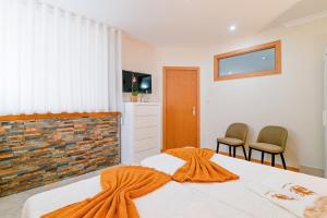 a bedroom with a bed with an orange blanket on it at Casa Tomé de Sousa in Rates