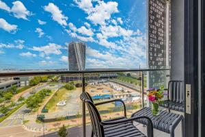 a balcony with two chairs and a view of a city at Serene Spaces, Ellipse in Midrand