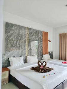 two beds in a hotel room with a flower on the bed at Rimnatee Resort Trang in Trang +120 photos