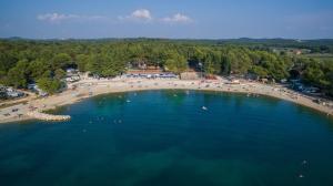 an aerial view of a beach with people in the water at Maistra Camping Valkanela Mobile homes in Funtana