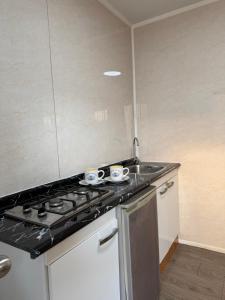 a kitchen with two cups on a stove top at Casa Withe opción jacuzzi estadía villa alemana in Villa Alemana