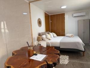 a bedroom with a bed and a wooden table with a table sidx sidx at Casa Withe opción jacuzzi estadía villa alemana in Villa Alemana