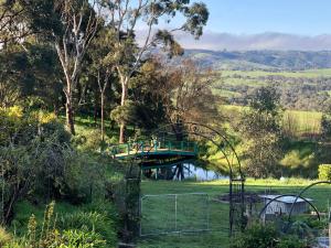 a bridge over a river in a field at Pear Tree Hollow in Bald Hills