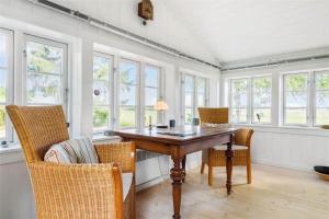 a dining room with a table and chairs and windows at 1035-Stege-Teglvaerksvej-39 in Stege