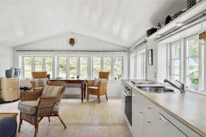 a kitchen with a table and chairs and windows at 1035-Stege-Teglvaerksvej-39 in Stege +18 photos