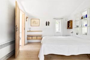 a white bedroom with a bed and a window at 1035-Stege-Teglvaerksvej-39 in Stege