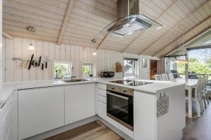 a kitchen with white cabinets and a stove top oven at FA066-Faxe-Ladeplads-Engsvinget-5 in Fakse Ladeplads