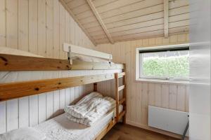 a small room with two bunk beds and a window at FA066-Faxe-Ladeplads-Engsvinget-5 in Fakse Ladeplads