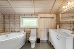 a bathroom with a tub and a toilet and a sink at FA066-Faxe-Ladeplads-Engsvinget-5 in Fakse Ladeplads +13 photos