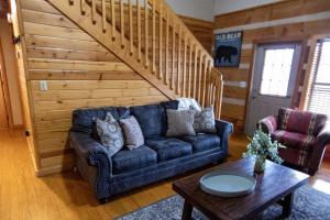 a living room with a blue couch and a wooden wall at Sweet Serenity in Gatlinburg +42 photos