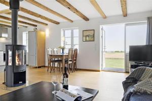 a living room with a fireplace and a table at 6005-Stege-Hjelmvej-15 in Stege