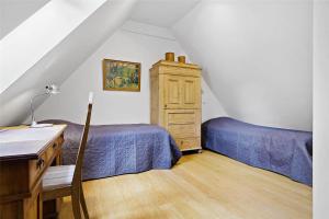 a attic room with two beds and a dresser at 6005-Stege-Hjelmvej-15 in Stege