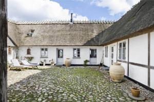 a courtyard of a white house with a roof at 6005-Stege-Hjelmvej-15 in Stege +14 photos