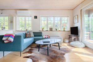 a living room with a blue couch and a table at 2002-Stege-Solvgranen-7 in Stege