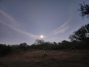 a sun is rising over a field with trees at Casa Rancho in El Ranchito