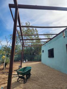 a green wheelbarrow sitting outside of a building at Casa Rancho in El Ranchito