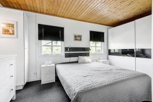 a bedroom with a bed with a wooden ceiling at R973-Rodvig-Stuven-61 in Rødvig
