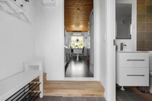 a kitchen with white cabinets and a dining room at R973-Rodvig-Stuven-61 in Rødvig +17 photos