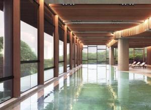 an empty lobby with a pool and windows at Antara Residence By KLIQ in Genting Highlands