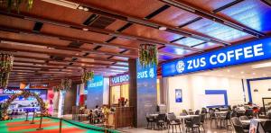 a convention hall with tables and chairs and abucks coffee sign at Antara Residence By KLIQ in Genting Highlands