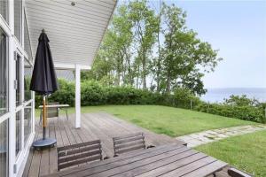 a patio with two benches and an umbrella on a house at 8164-Praesto-Klintestien-16 in Præstø +5 photos