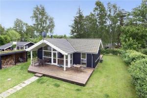 a small house with a deck in a yard at 8164-Praesto-Klintestien-16 in Præstø