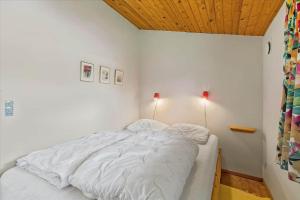 a white bed in a room with a wooden ceiling at 1055-Stege-Rylevej-21 in Stege