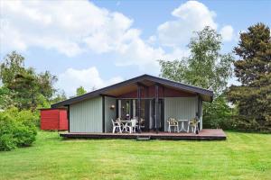 a small house with a deck on a grass field at 1055-Stege-Rylevej-21 in Stege