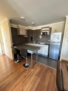 a kitchen with a table and a refrigerator at Departamento en Temuco O'Higgins in Temuco