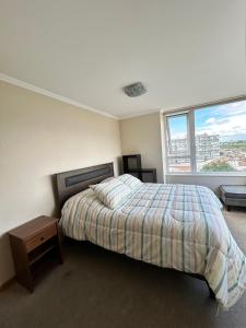a bedroom with a bed and a large window at Departamento en Temuco O'Higgins in Temuco