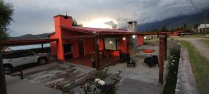 a red house with a car parked in front of it at Casa tafi in Tafí del Valle