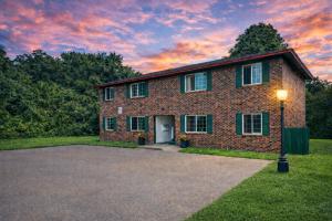 a brick house with a sunset in the background at The Homestead Luxury Cozy 2BR Apartment in Nacogdoches Near SFA University and Downtown Pet Friendly Business Ready Extended Stays Welcome with Self Check In High Speed WiFi Full Kitchen In Unit Laundry Private Parking and Quiet Comfort in Nacogdoches