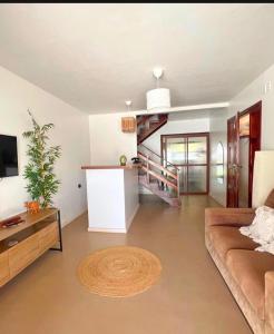 a living room with a couch and a stairway at Casa levante in Paracuru