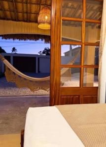 a bedroom with a hammock and a view of a beach at Casa levante in Paracuru +11 photos