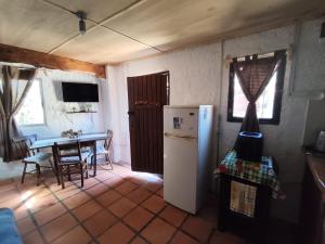 a kitchen with a refrigerator and a table with a dining room at Eywa in Punta Del Diablo