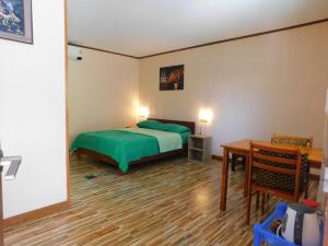 a bedroom with a green bed and a desk at Swiss Bonihouse Koh Yao Yai in Ban Pru Nai