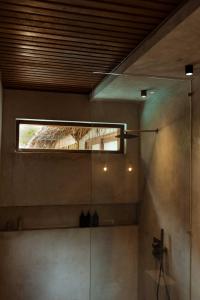 a bathroom with a shower with a window in it at RONJA Boutique Hotel - Adults Only in Uluwatu